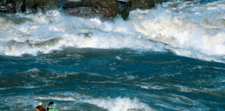 a whitewater kayaker paddling among large rapids on the Slave River