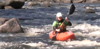 woman whitewater kayaker demonstrates the sweep stroke in a series of small rapids