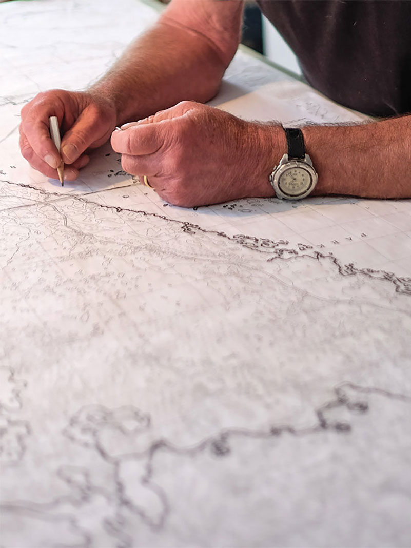 man's hands drawing a map