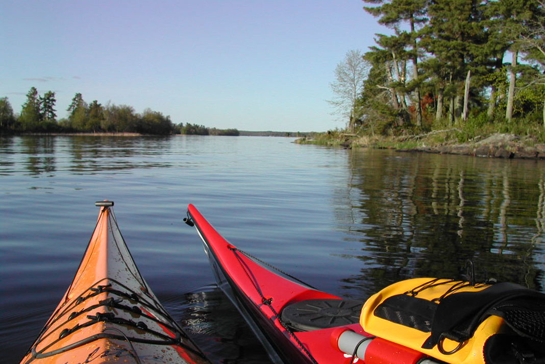 bows of two touring kayaks on a lake in Voyageurs National Park