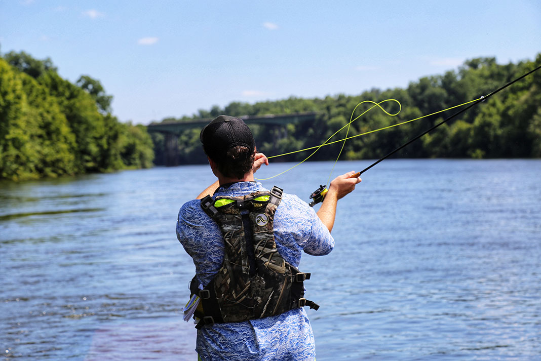 man fly fishing with a pfd