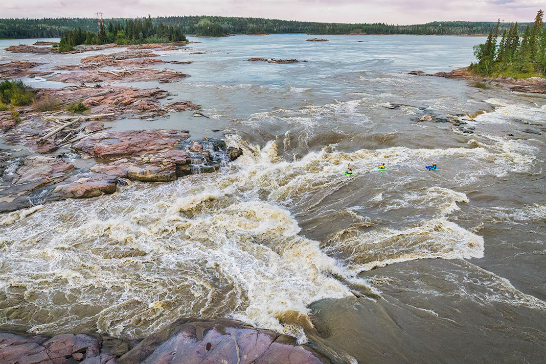 whitewater kayakers paddle into the Mountain Portage Rapids on the Slave River
