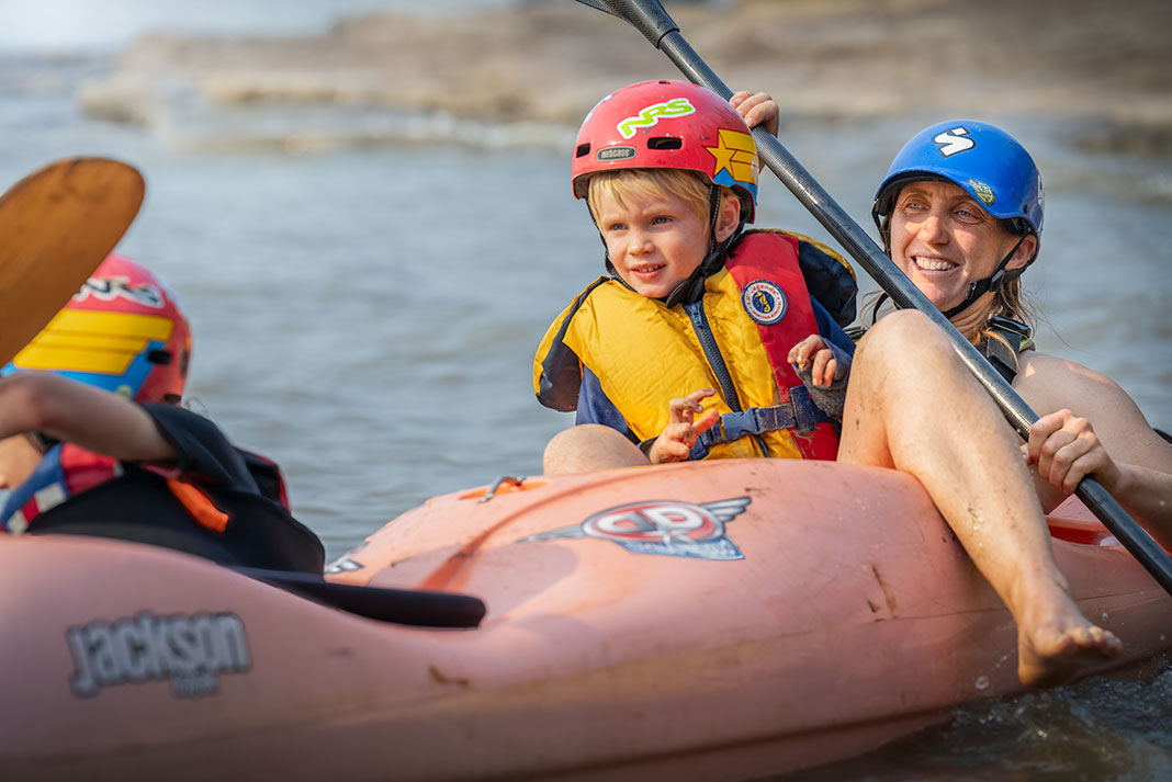 woman and child doing relaxed river paddling in a whitewater boat