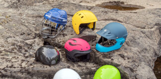 a selection of whitewater helmets are arranged on a river rock