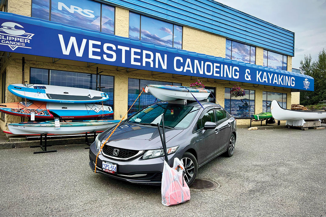 A customer leaves Western Canoeing & Kayaking with a Pelican kayak and accessories