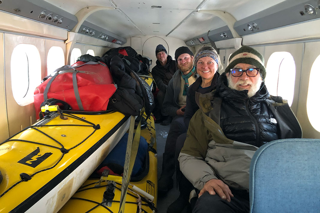 the Arctic Cowboys pose in the plane with their kayaks after the expedition