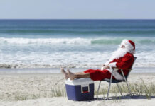 santa relaxing with his feet up at the beach