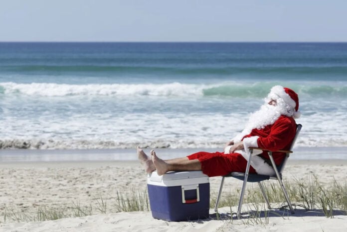 santa relaxing with his feet up at the beach