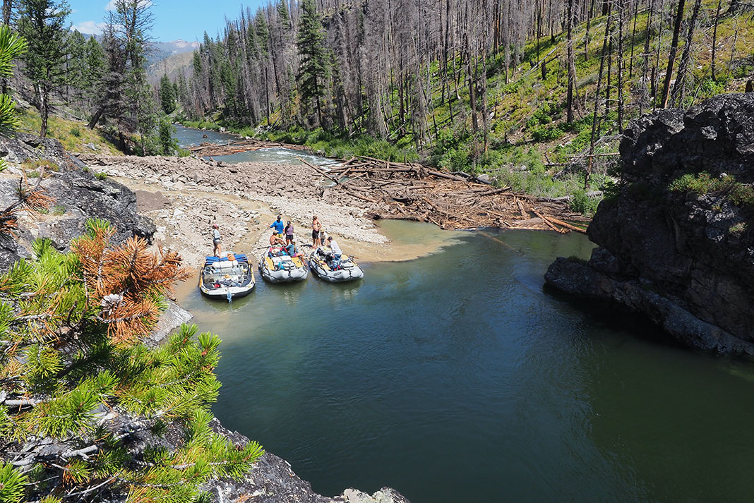 three whitewater rafts portage past a rockfall and snag of deadfalls on the Middle Fork