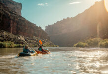 two packrafters paddle down the sunny San Juan River on trip