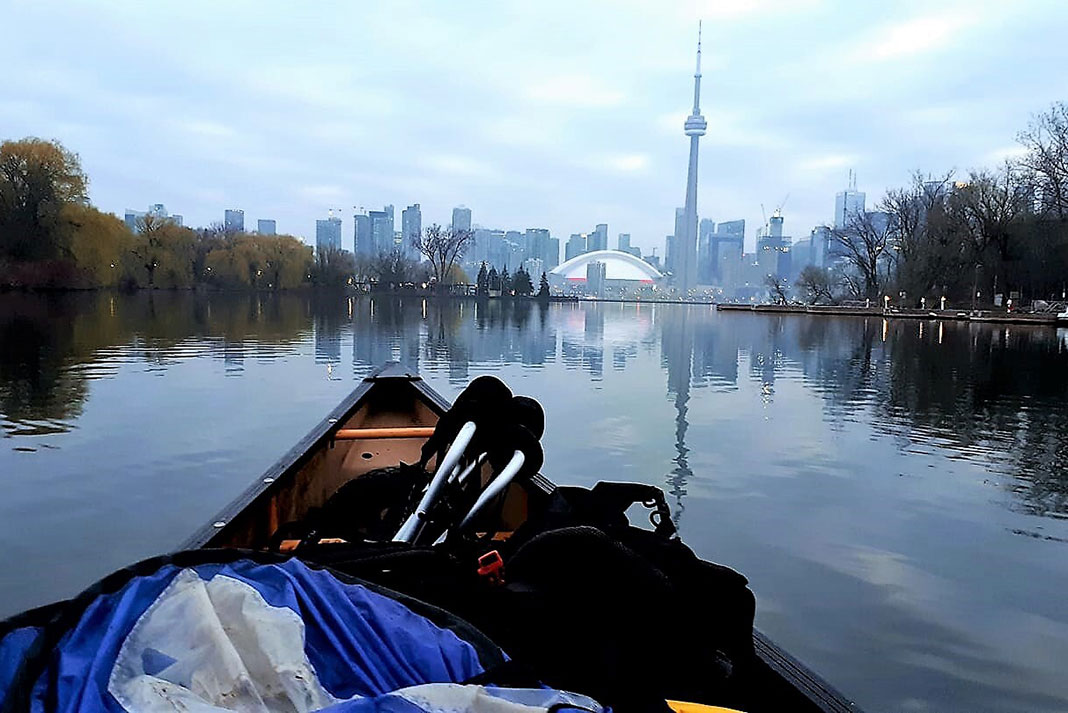 bow shot of a canoe paddling in the Toronto Islands with CN Tower and skyline in background