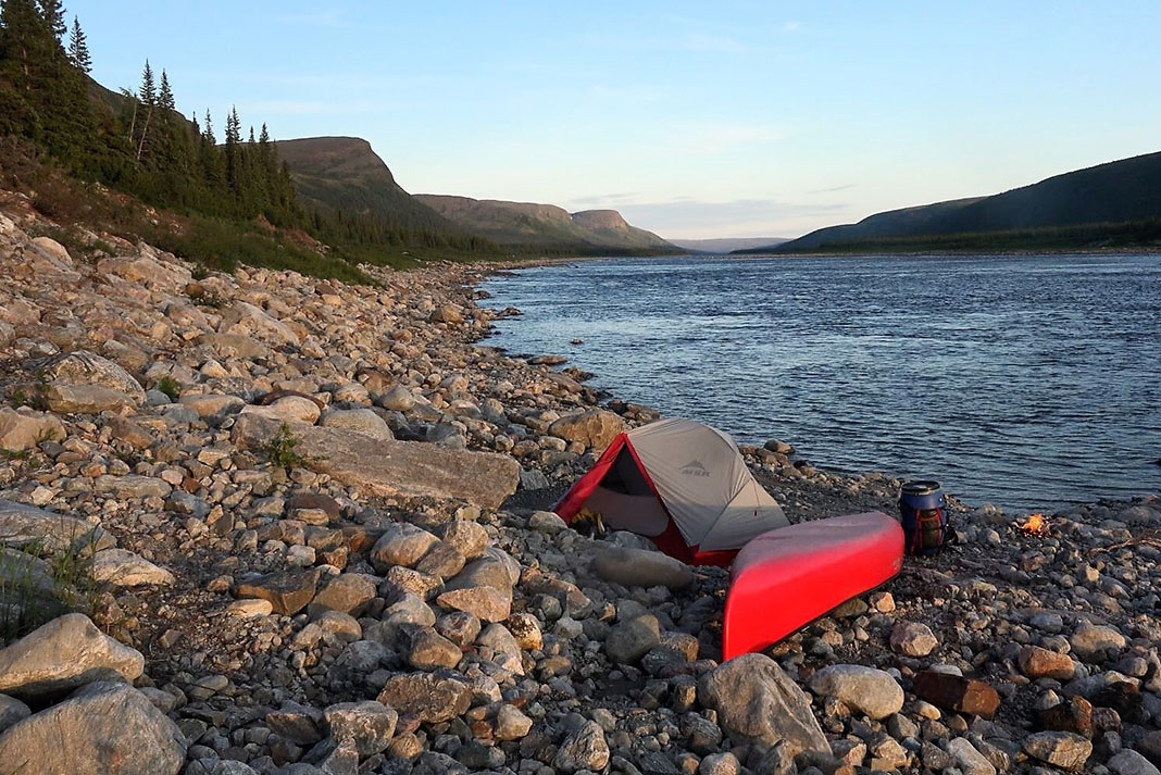 canoe and tent on rocky beach in Canada's north