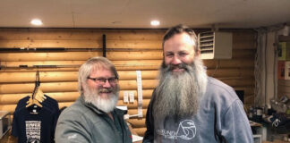 the previous and new owners of Churchill River Canoe Outfitters shake hands