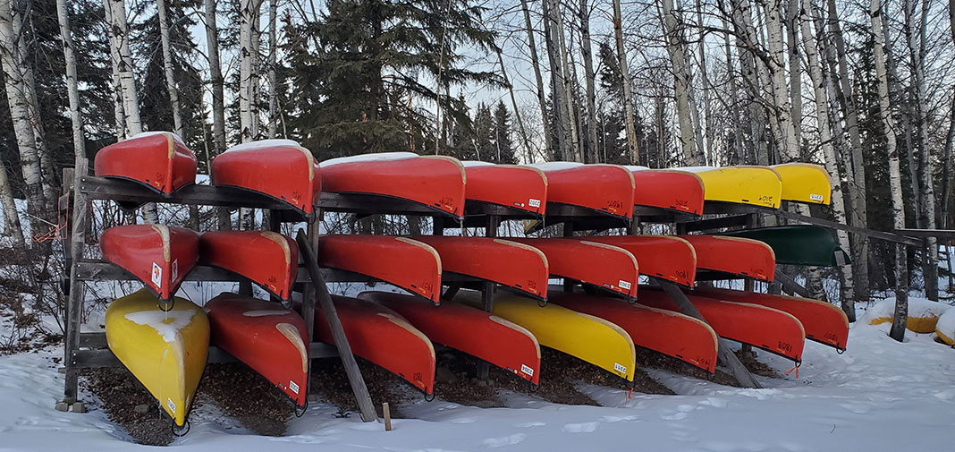 a large canoe rack with canoes in winter at Churchill River Canoe Outfitters