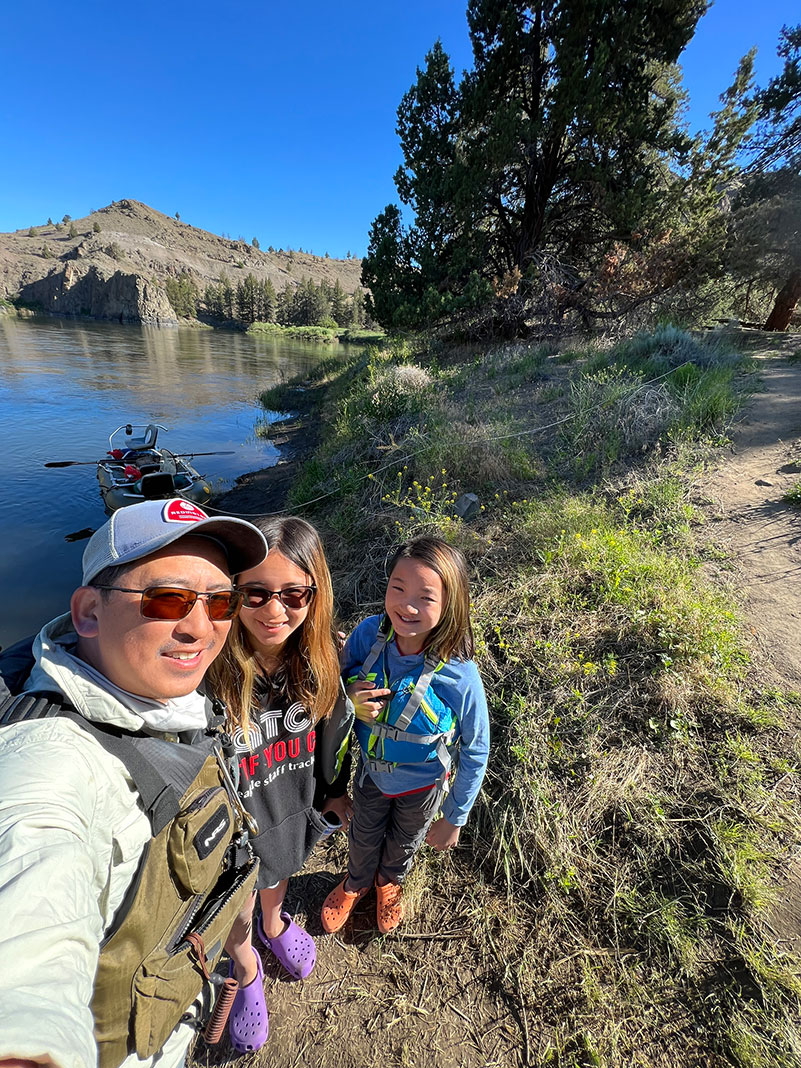 father and two daughters pose with boat at the John Day riverbank