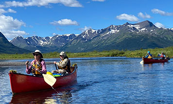two tandem canoes paddle on an idyllic northern canoe trip on the Turnagain River
