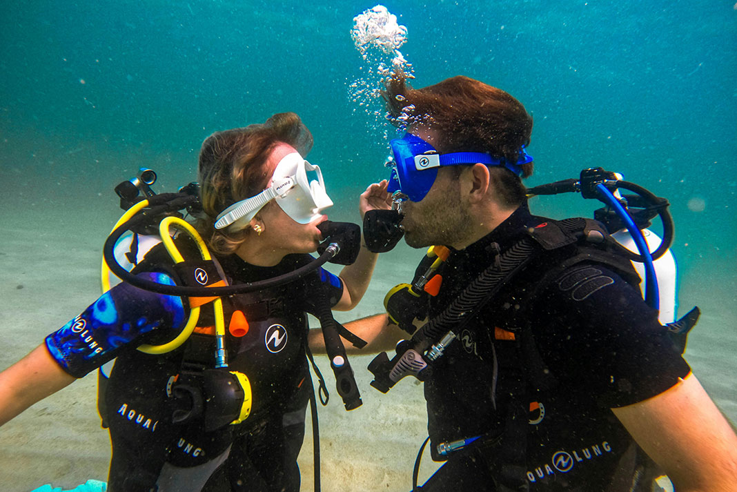 man and woman scuba diving wearing Aqualung equipment