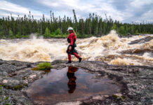 Benny Marr walks past a large rapid on the Nottoway River in Northern Canada