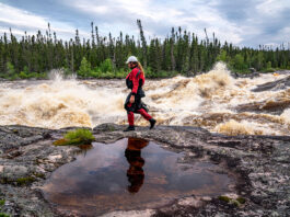 Benny Marr walks past a large rapid on the Nottoway River in Northern Canada