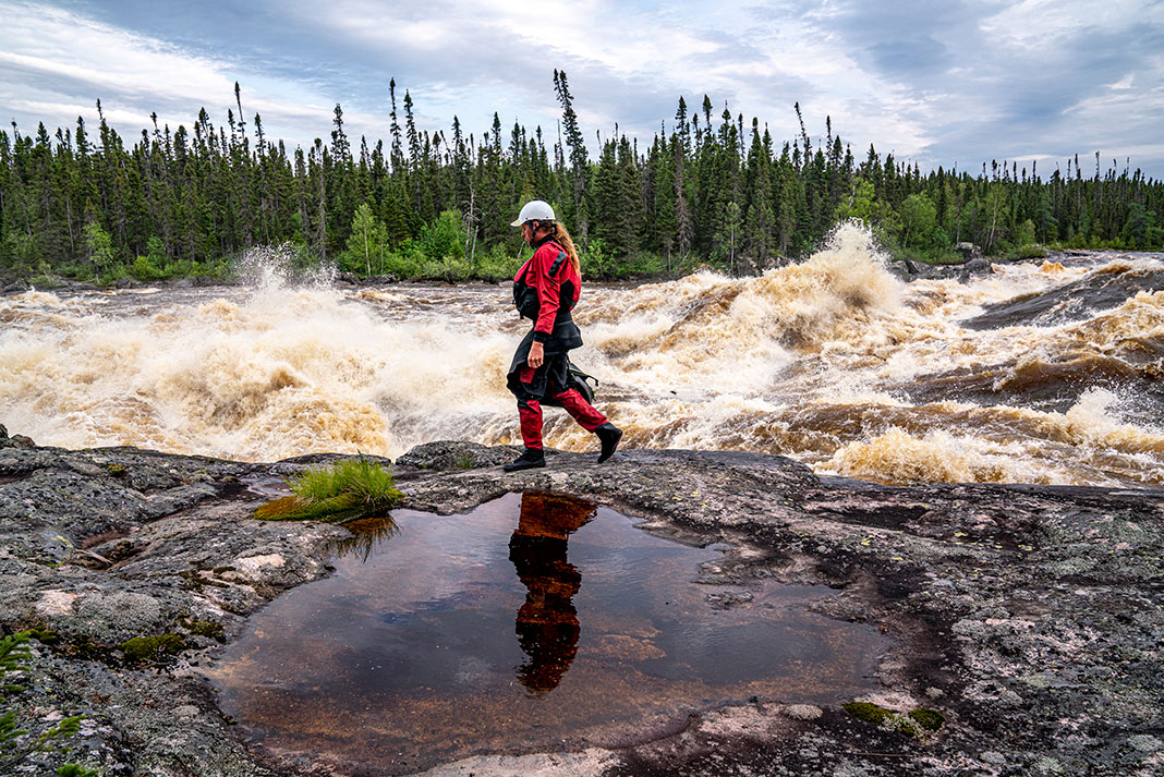 Benny Marr walks past a large rapid on the Nottoway River in northern Canada