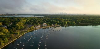 drone shot of Lake Harriet in Minnesota's Chain of Lakes showing moored sailboats with city in background