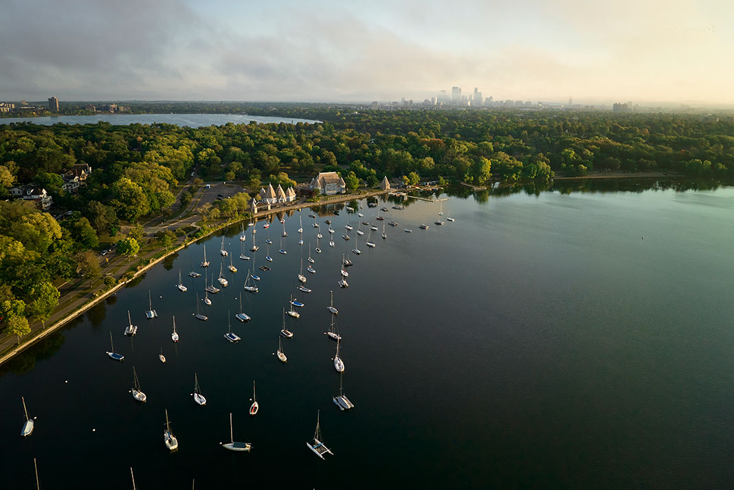 drone shot of Lake Harriet in Minnesota's Chain of Lakes showing moored sailboats with city in background
