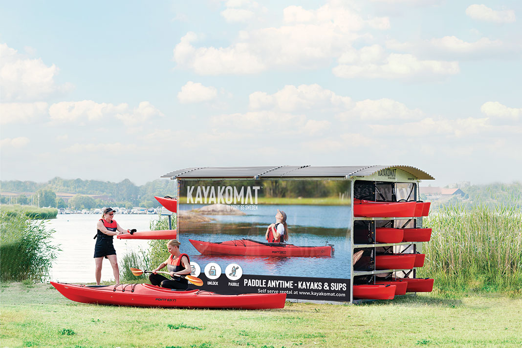 a woman rents a kayak from an automated Kayakomat stand