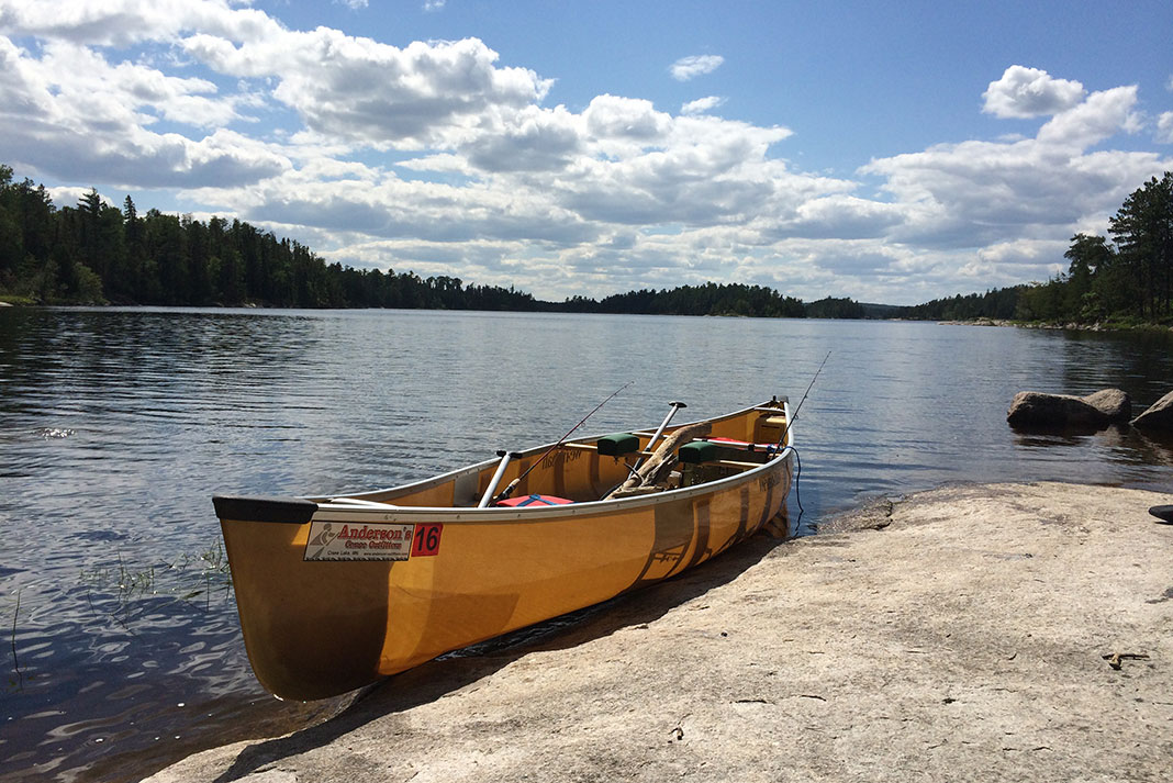 ultralight canoe sits on rocky shoreline on a Minnesota lake