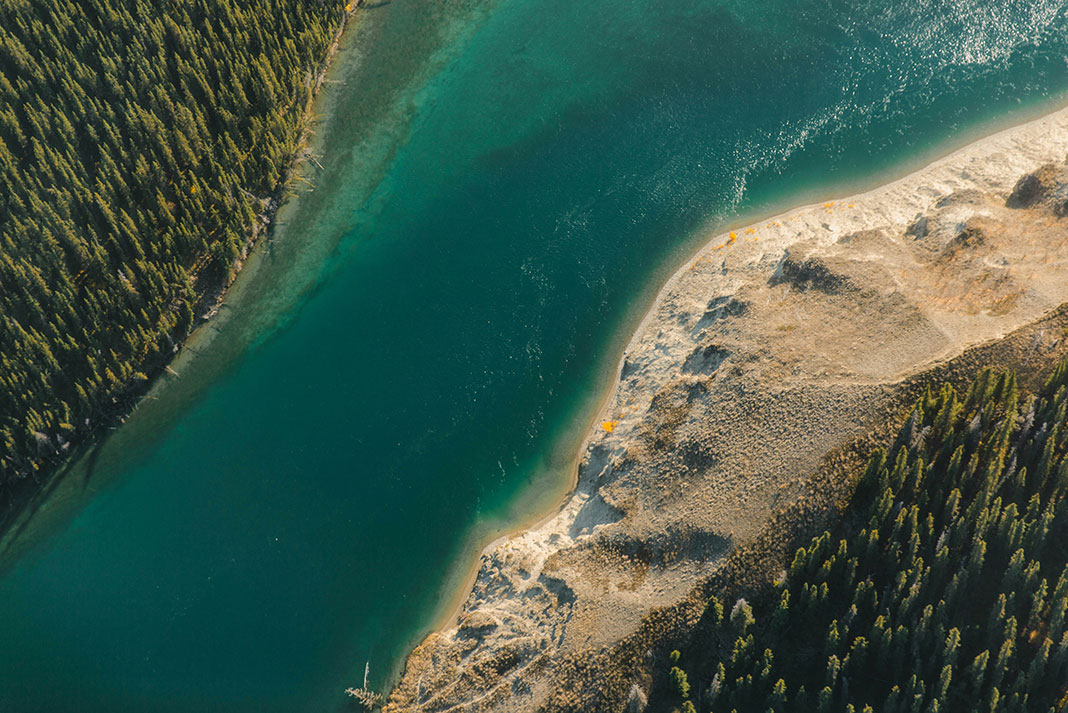 overhead view of a turquoise river with sandy, forested banks in the Yukon