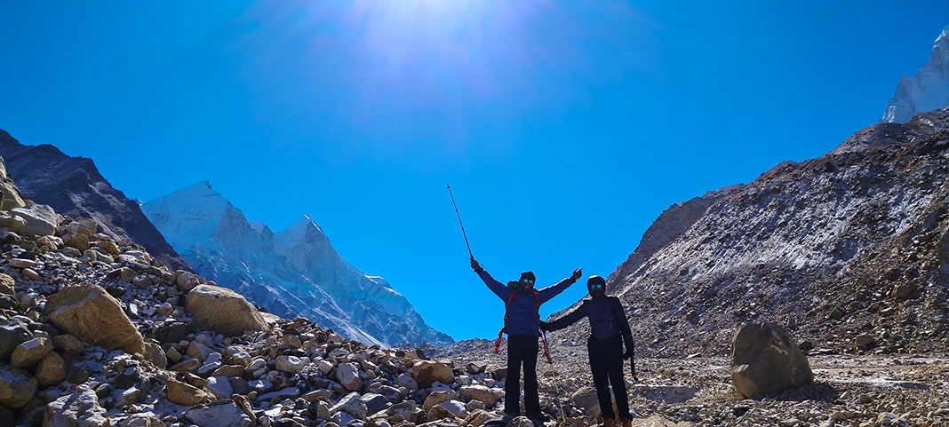 two hikers pose in a mountain pass in India