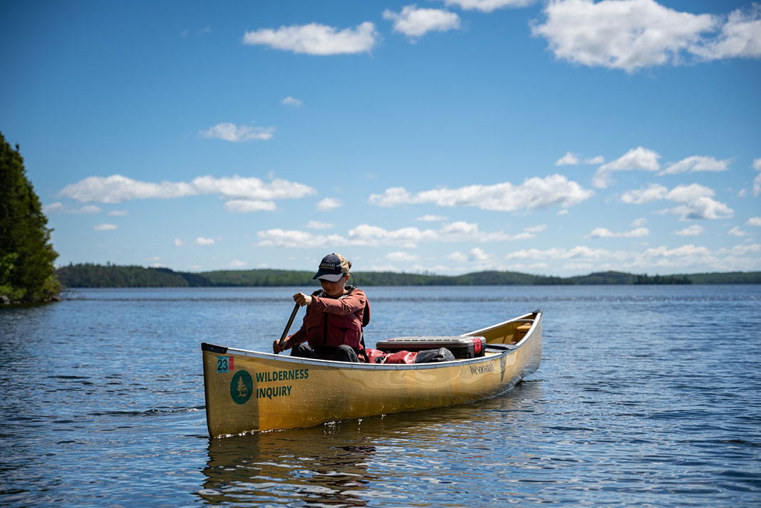 woman paddles a canoe on a Wilderness Inquiry trip in Minnesota