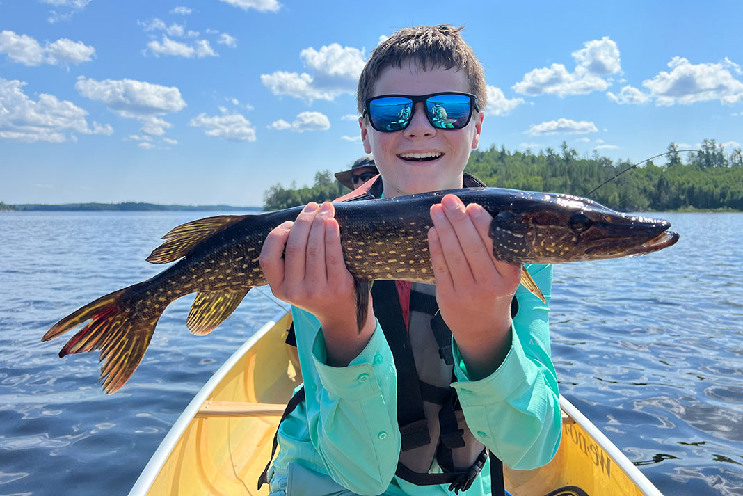 boy holds up a fish caught on a Boundary Waters canoe trip