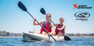 two women paddle a tandem kayak on a sunny day while wearing Stohlquist PFDs, recently acquired by Sport Dimension