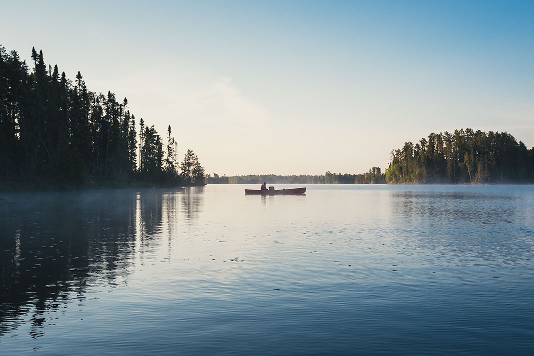 a canoe floats on a tranquil lake in northwestern Ontario