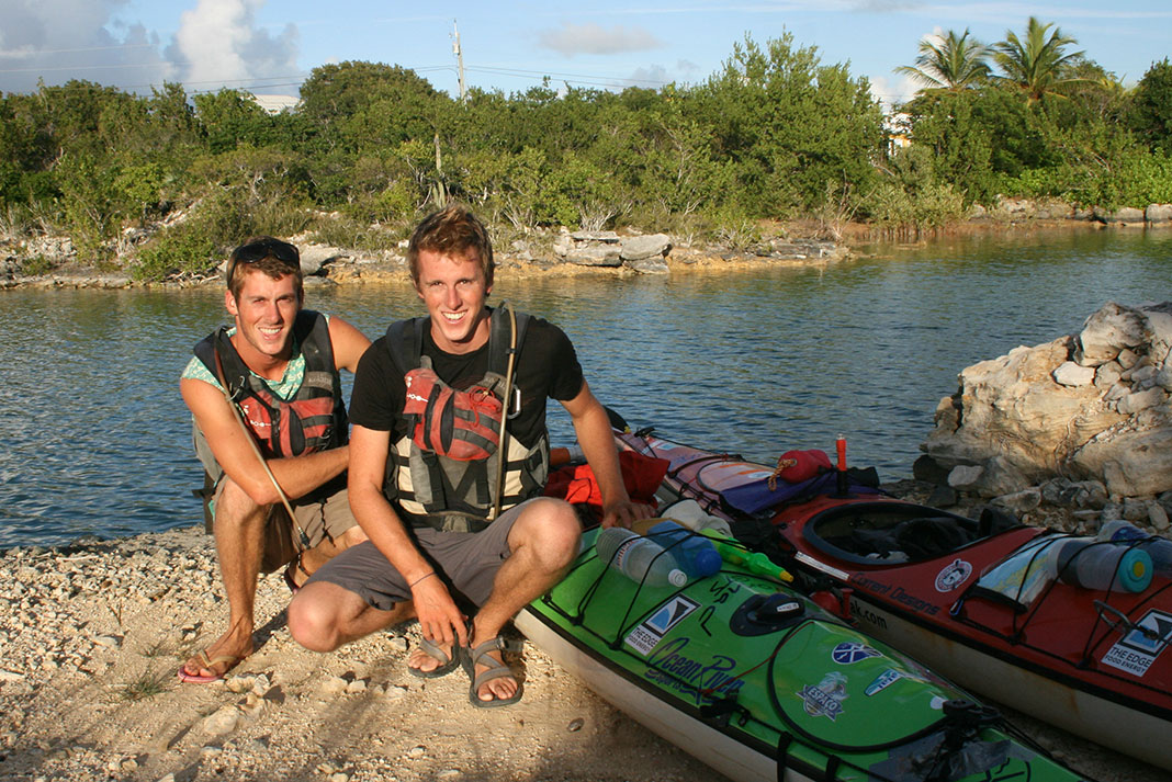 the Henry brothers pose beside their kayaks while on their expedition