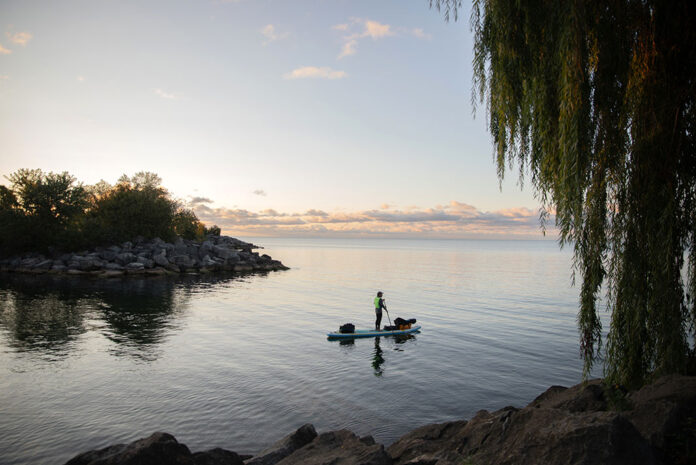 Dan Rubinstein stands silhouetted on his paddleboard during a SUP expedition that would teach him many paddling life lessons