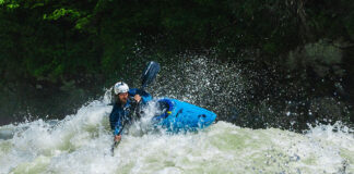 a whitewater kayaker paddles through rapids after satisfying the pre-run superstitions he observes