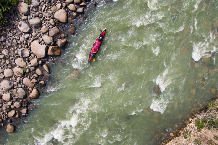 overhead view of a tandem paddling expedition boat travelling down a river