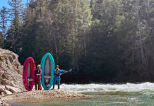 two women kayakers pose by the water with AIRE's Spud and Tater inflatable whitewater kayaks