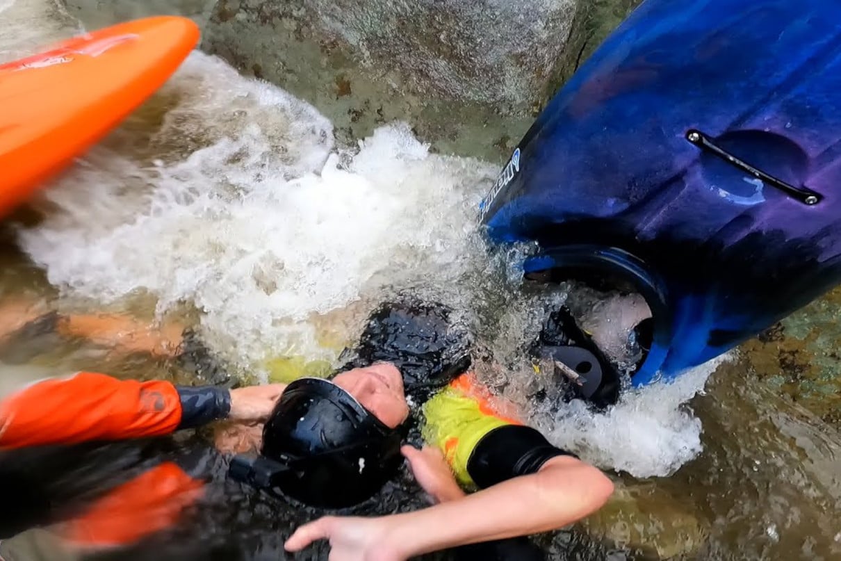 Whitewater kayaker being pulled out of a siphon during rescue on Linville River.